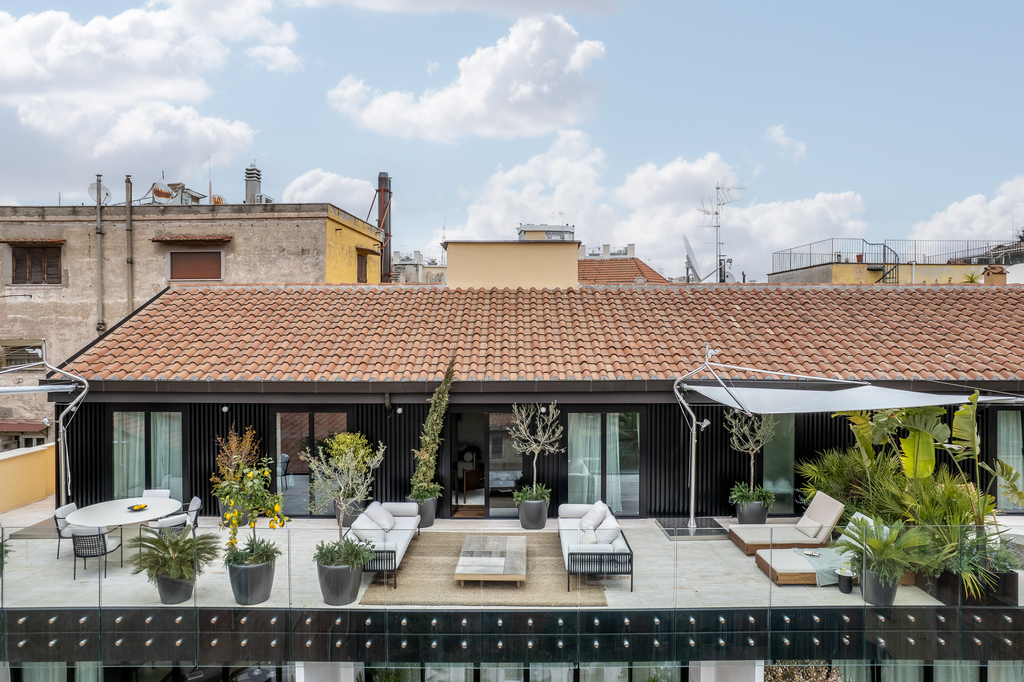 Spacious penthouse terrace at master Trevi Rome Aparthotel with outdoor seating and panoramic rooftop views