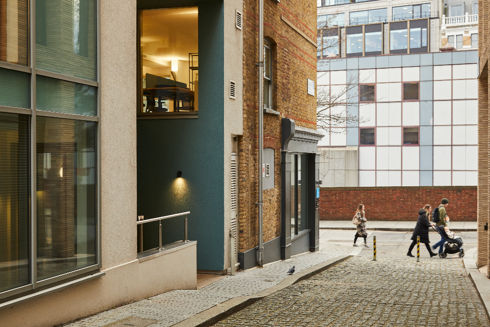 Quiet street view near master Farringdon London serviced apartments, showing a mix of modern and historic buildings with pedestrians walking.