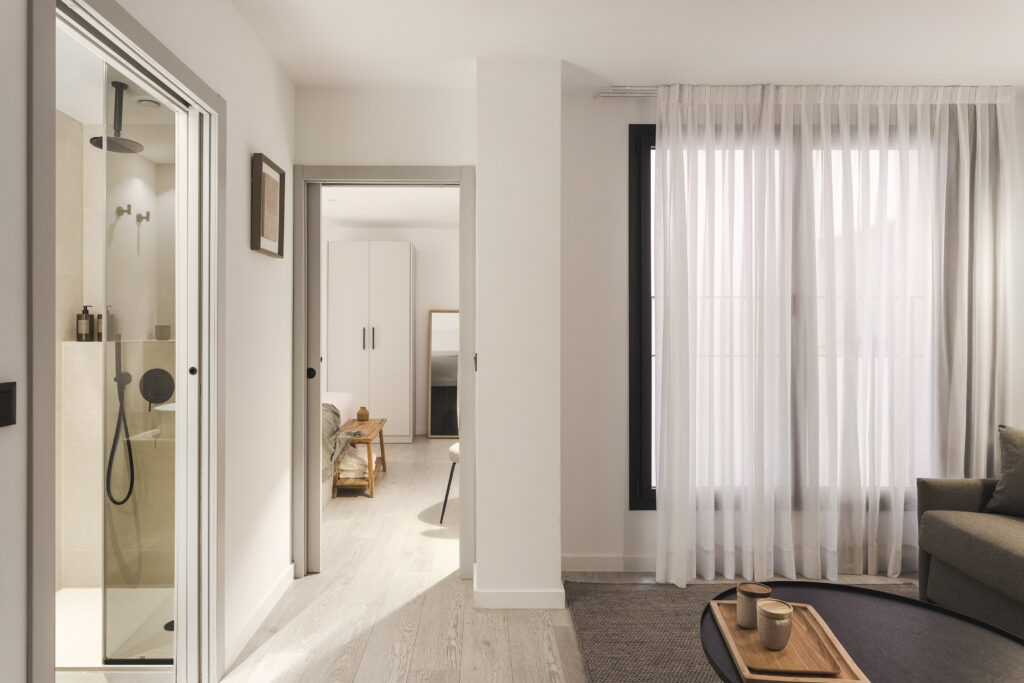 Bright apartment interior at master La Rambla Barcelona showing modern bathroom, hallway, and access to the bedroom.