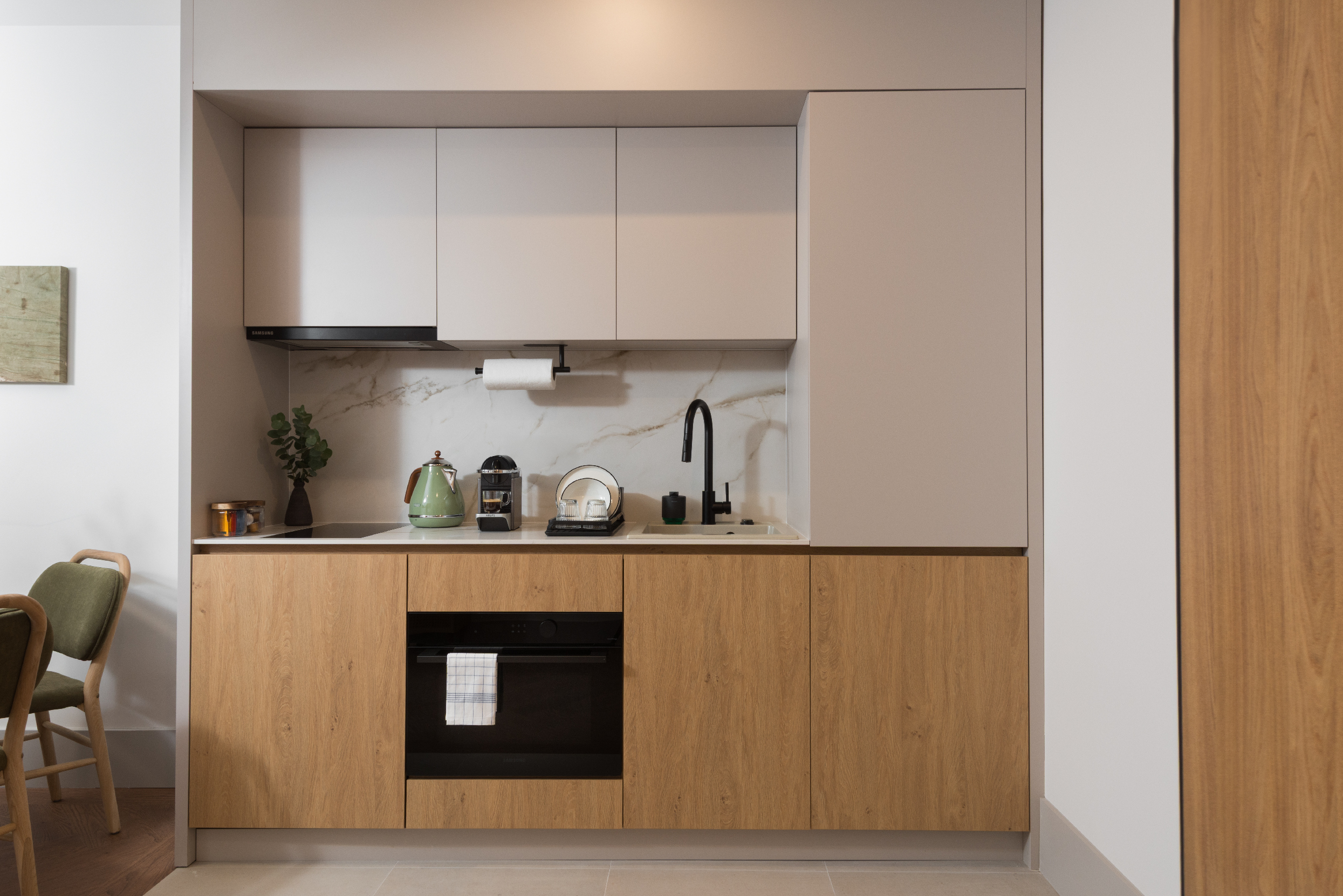 Fully equipped kitchenette in the Family Apartment at master Wola Warsaw with modern cabinetry, oven, sink, and compact workspace.